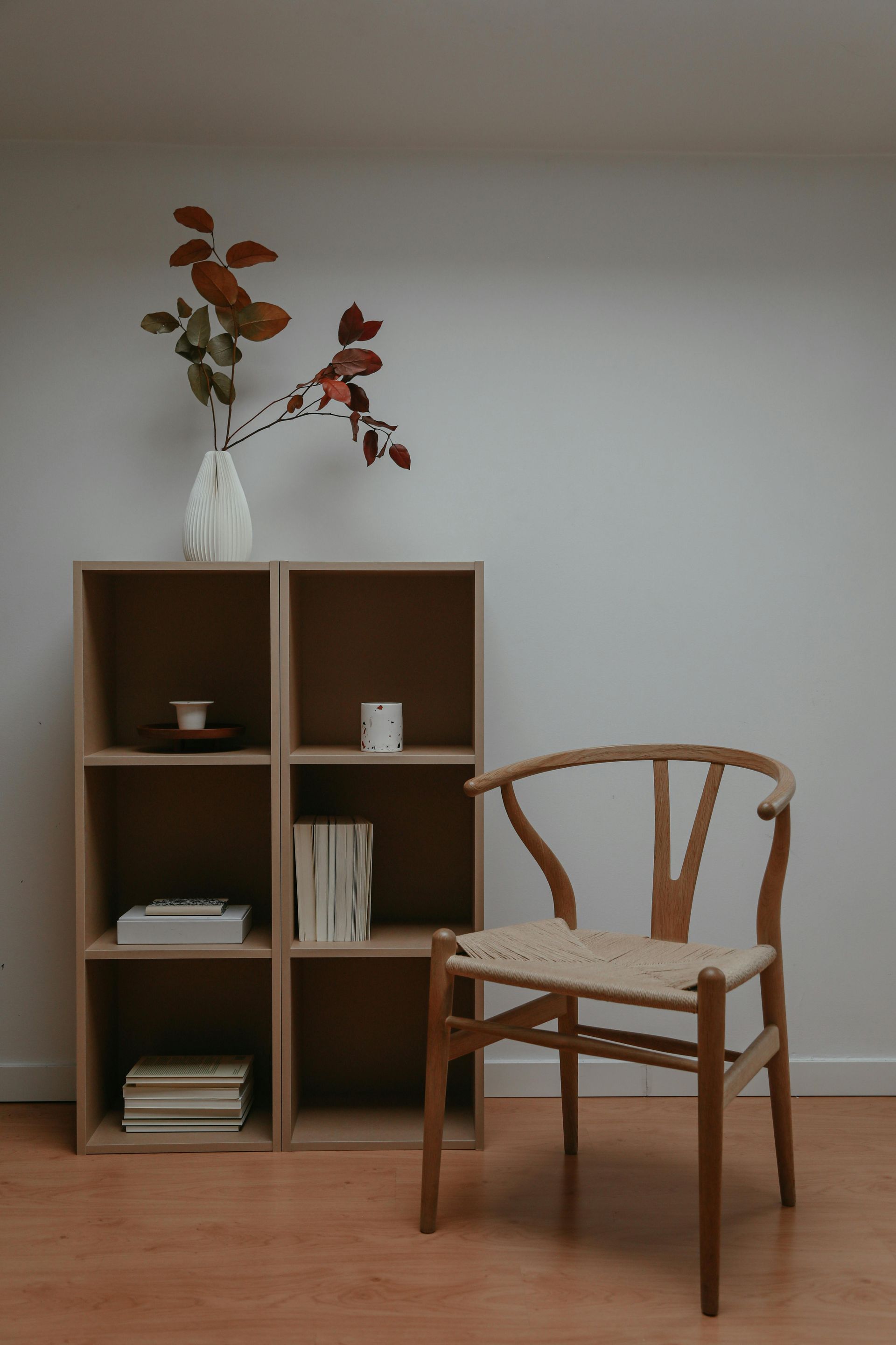 A chair is sitting next to a bookshelf in a room.