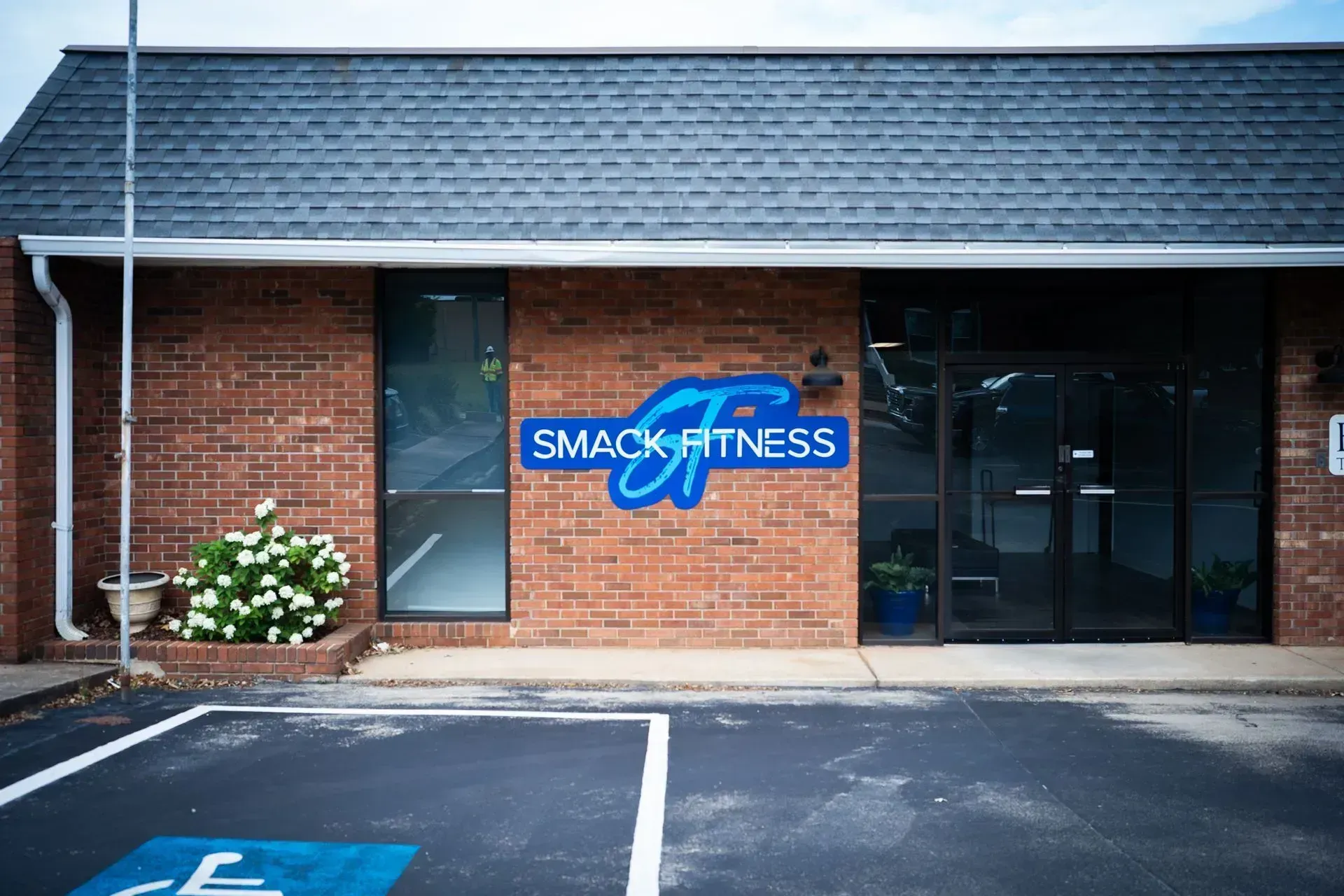 Smack Fitness storefront with brick facade, blue sign, and glass entrance.