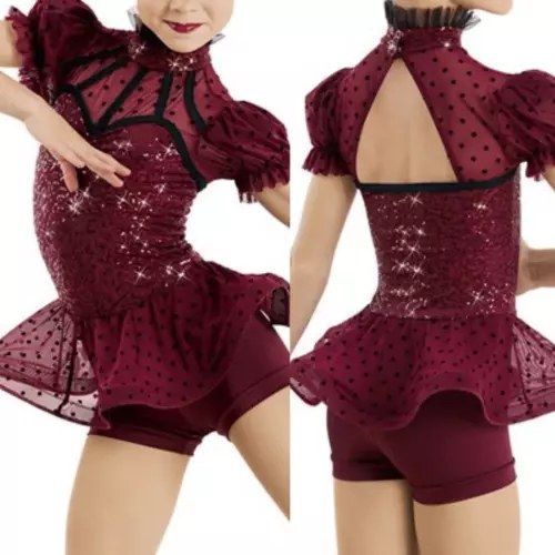 A girl is wearing a burgundy dress with polka dots and shorts
