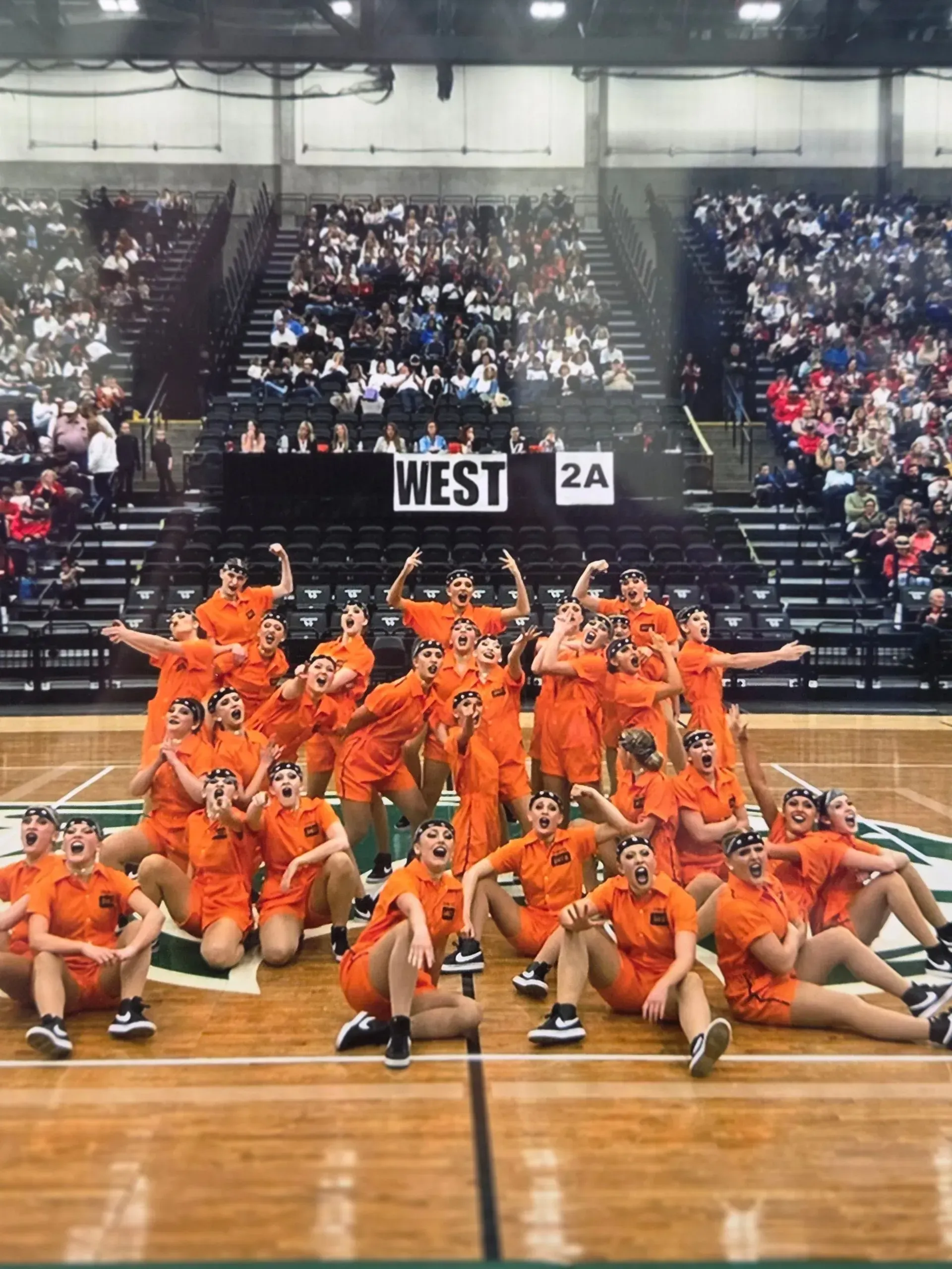 A group of people are posing for a picture on a basketball court.