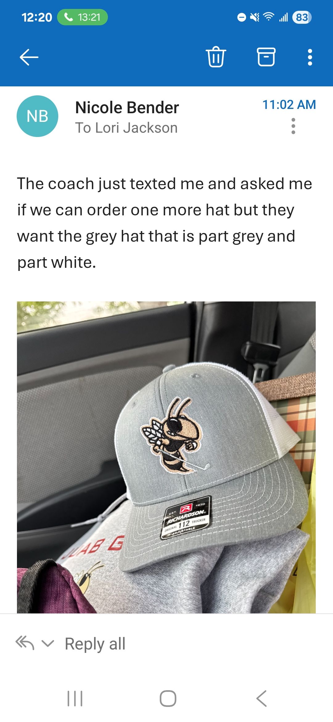 A text message with a photo of a silver hat with a logo.