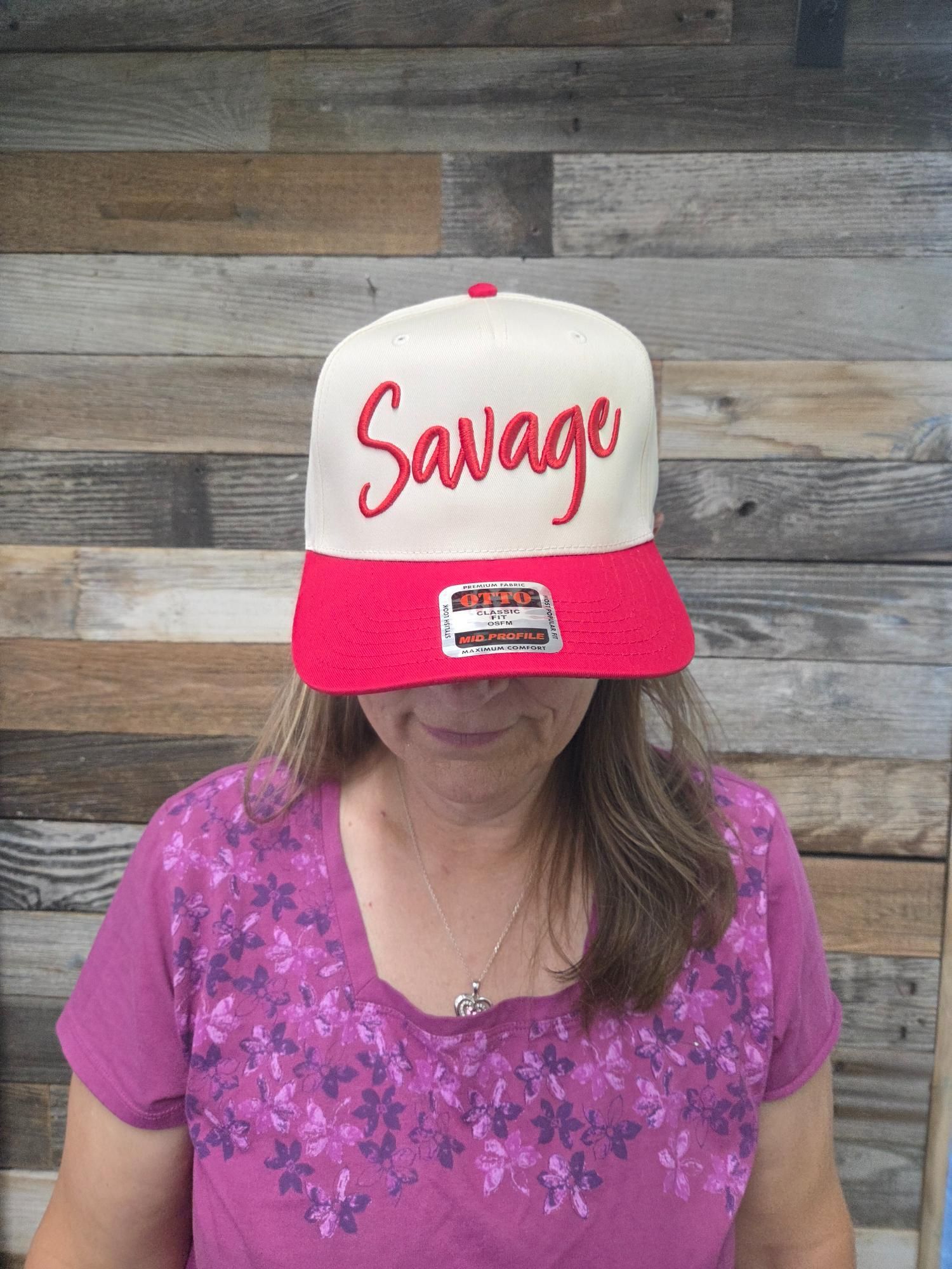 Woman wearing a white and red baseball cap that says 