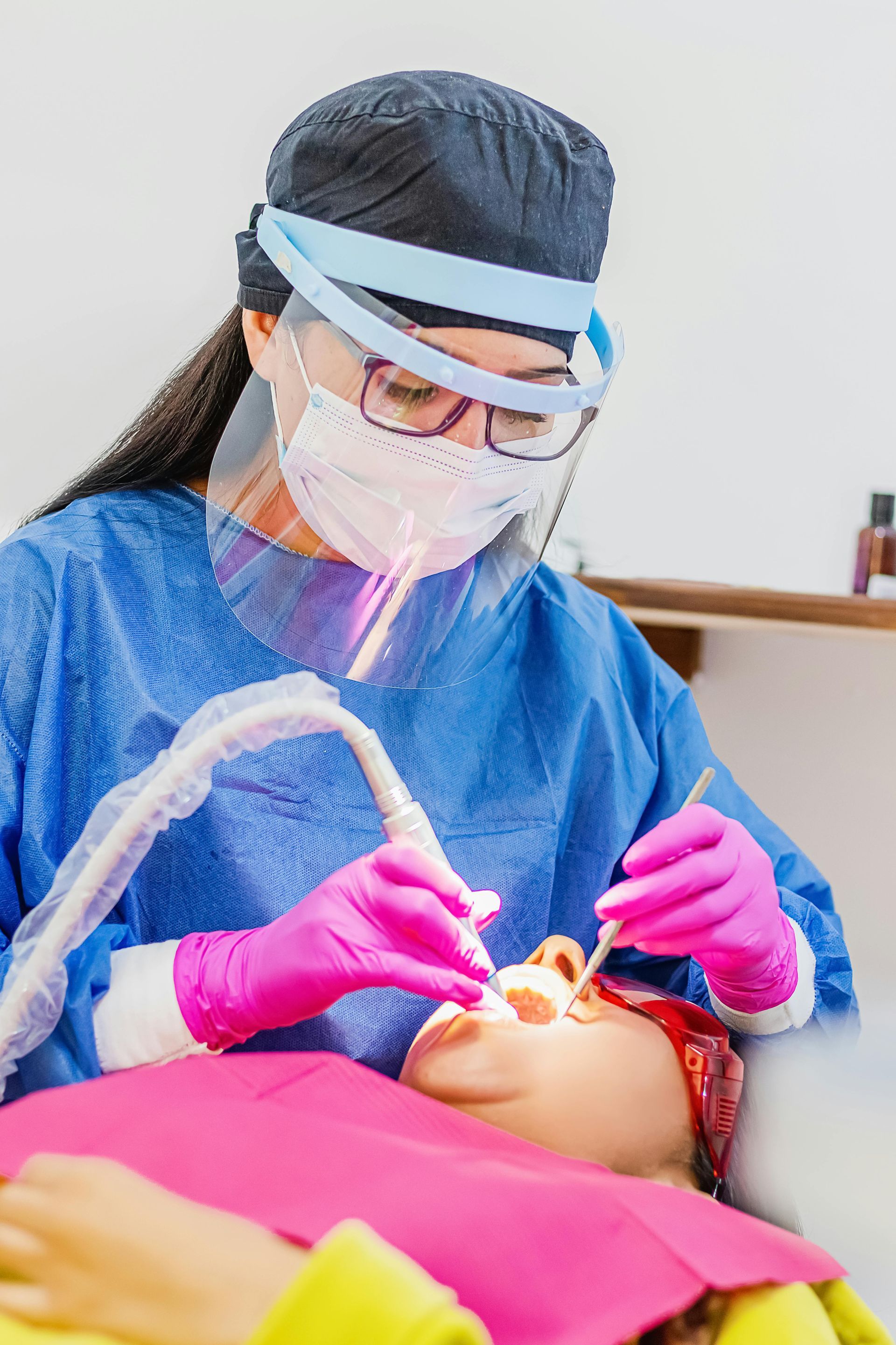 A dentist is examining a child 's teeth in a dental office.