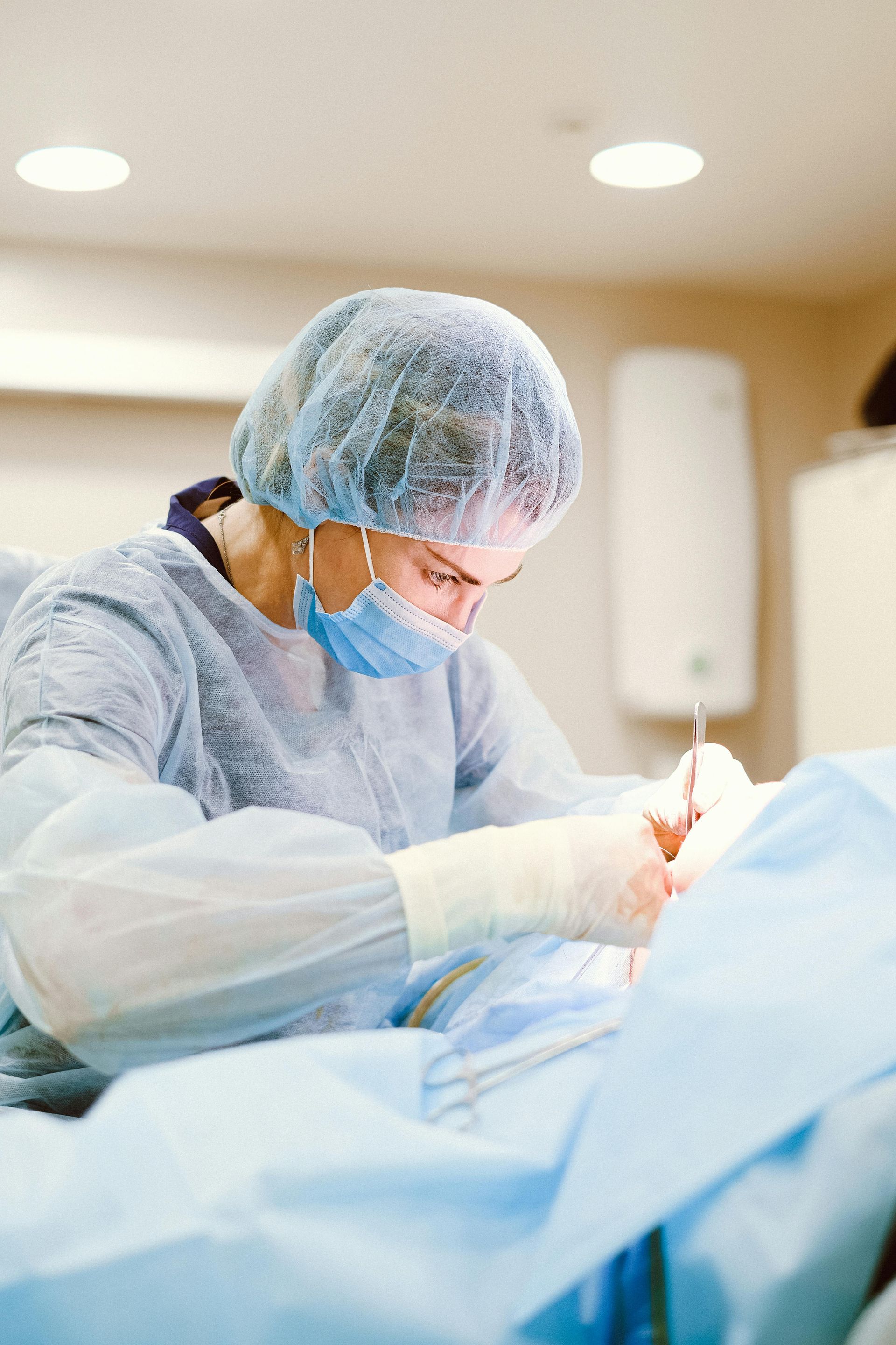 A surgeon is operating on a patient in an operating room.