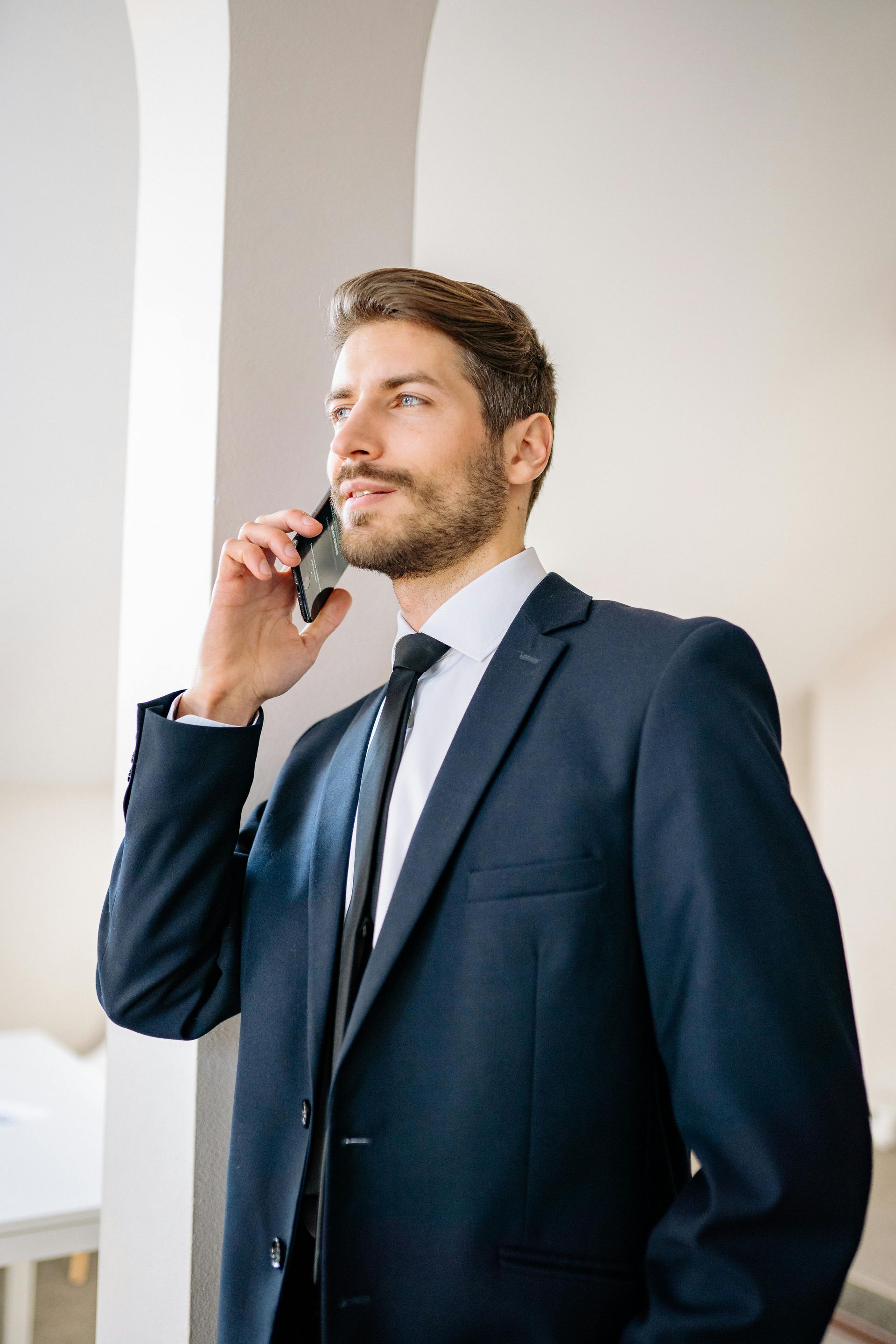 A man in a suit and tie is talking on a cell phone.