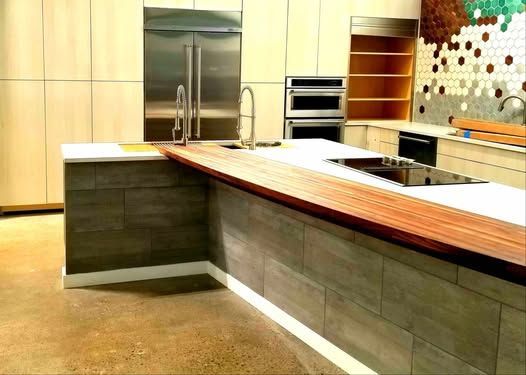 A kitchen with a large island and stainless steel appliances