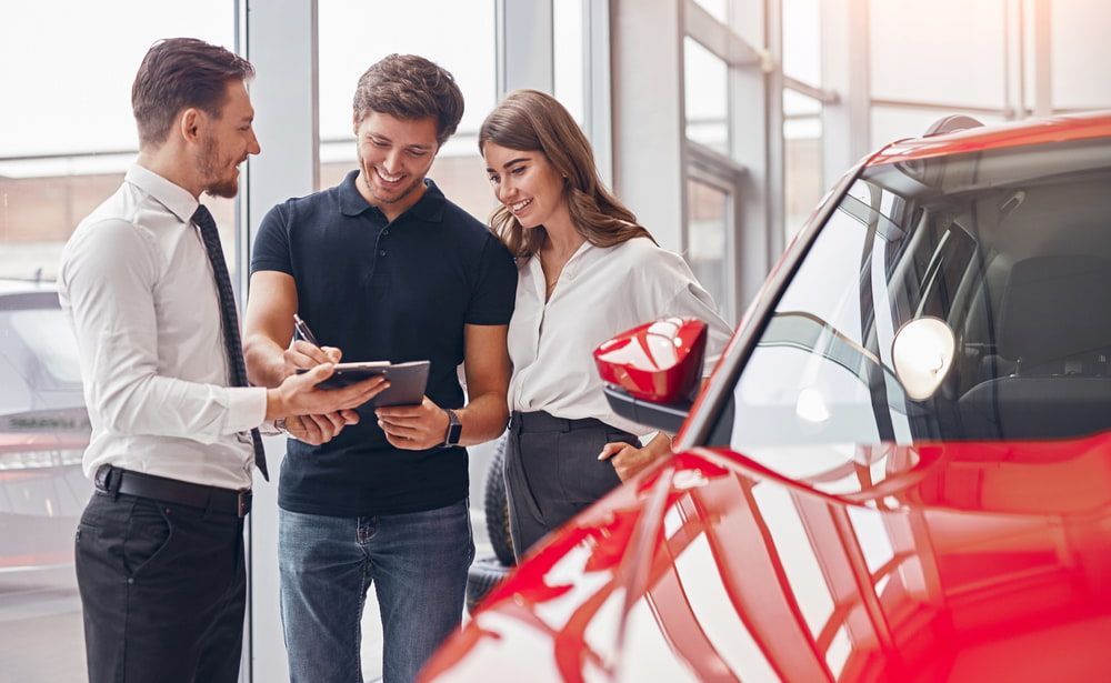 Car Dealership Salesperson Showing Paperwork to Customers — Old School Custom And Collision in Fawkner, VIC