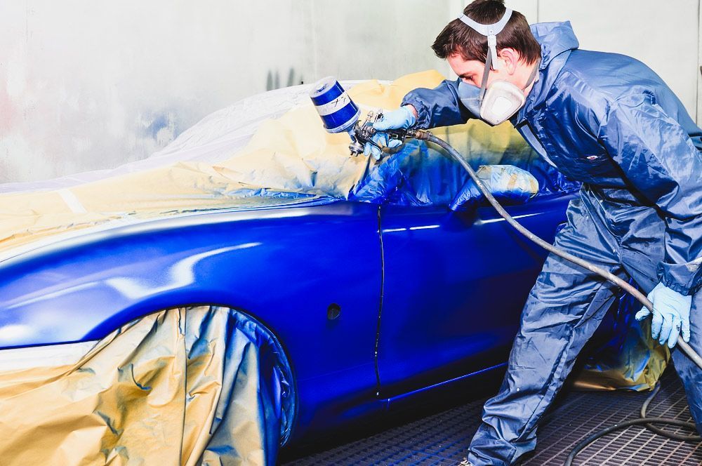 Workers Spray-Painting a Blue Car in A Car Shop — Old School Custom And Collision in Fawkner, VIC