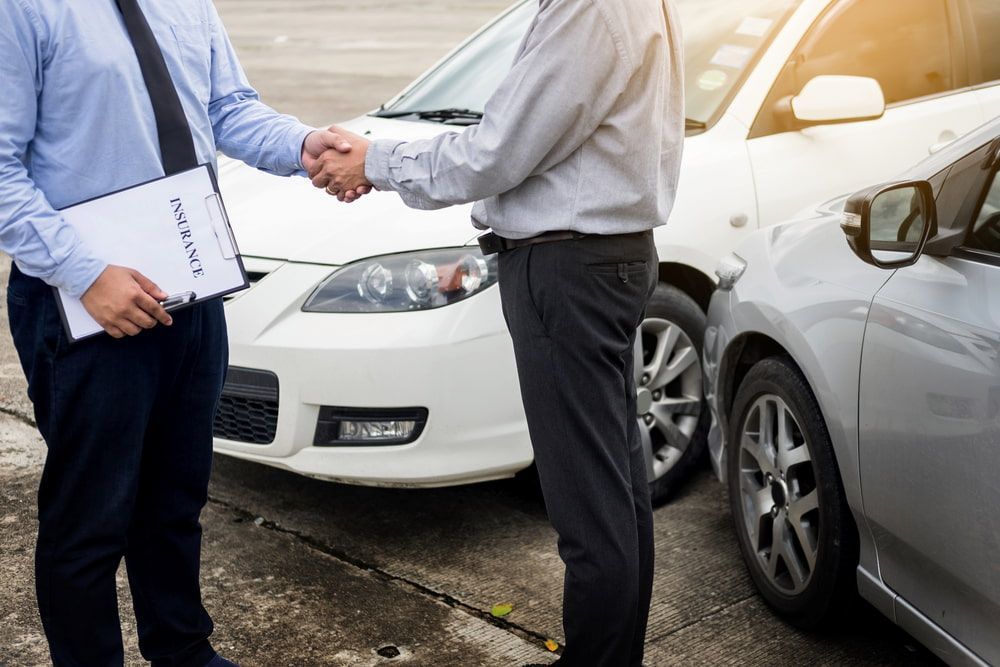 Two Men Are Shaking Hands In Front Of Two Cars — Old School Custom And Collision in Fawkner, VIC
