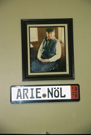 Framed photo of elderly man, and a license plate that says