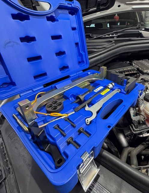 A mechanic shop with cars being worked on; a workbench with tools on the side.| Arie Nol Auto Center