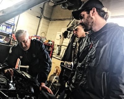 Three people looking on a car | Arie Nol Auto Center