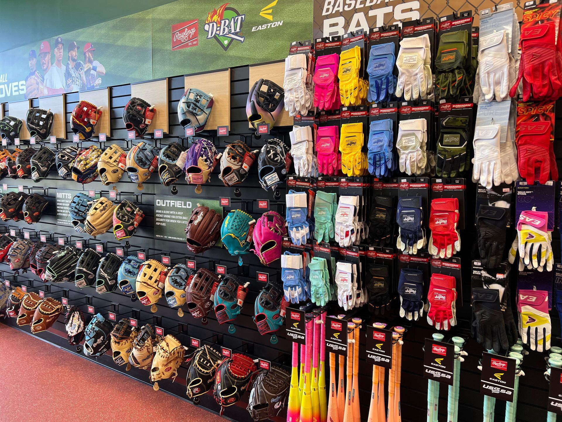 Wall of colorful sports gloves and gear displayed in a retail store aisle