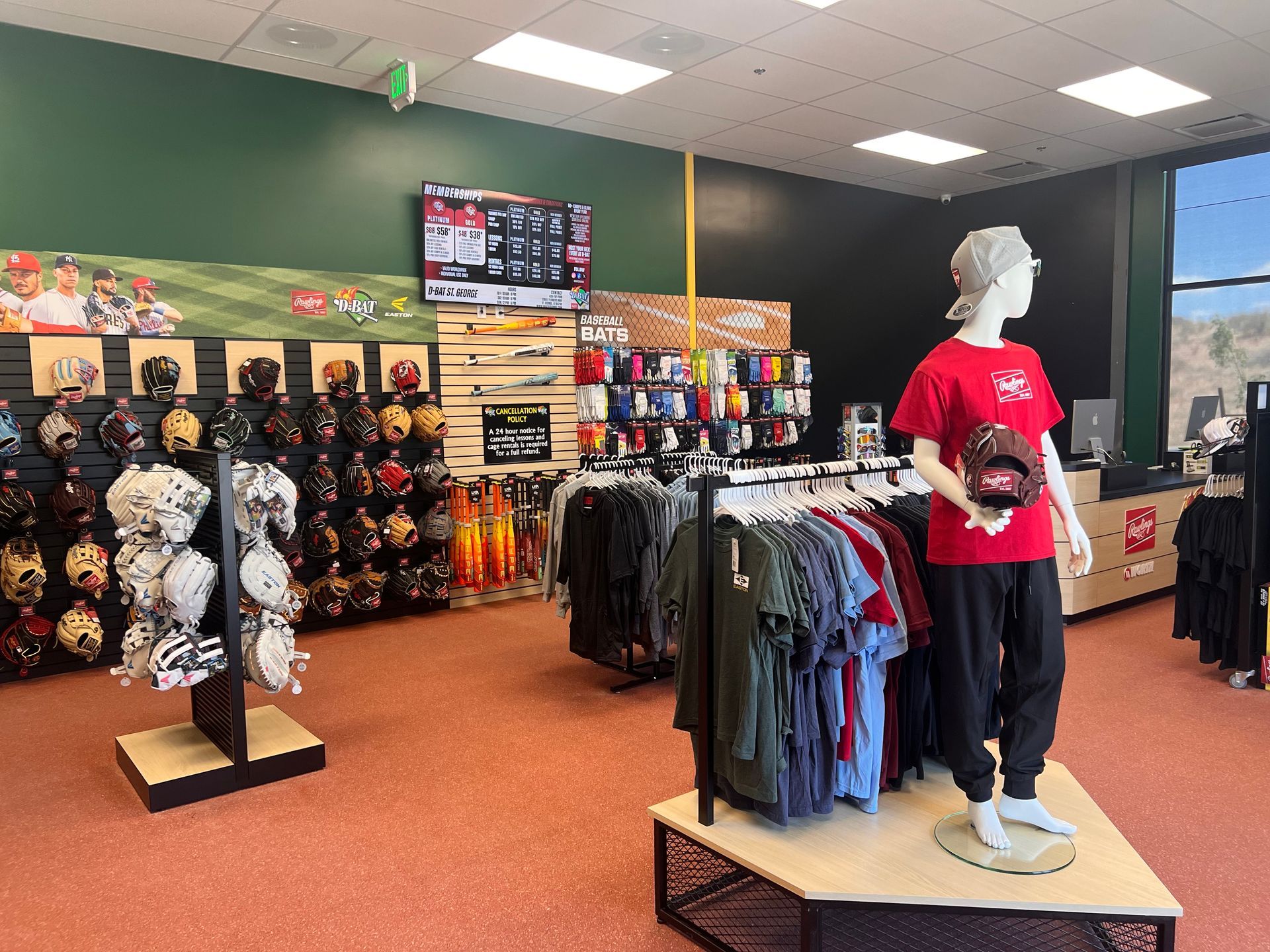Clothing store interior with racks of shirts and a mannequin wearing a red top and dark pants.