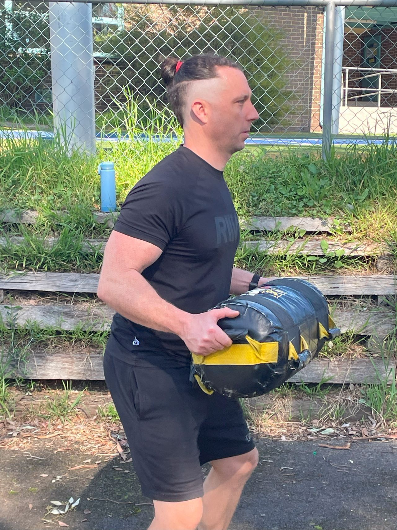 Members carrying weight bag as part of obstacle course