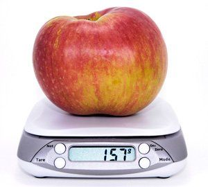 Apple sitting on top of a set of kitchen scales