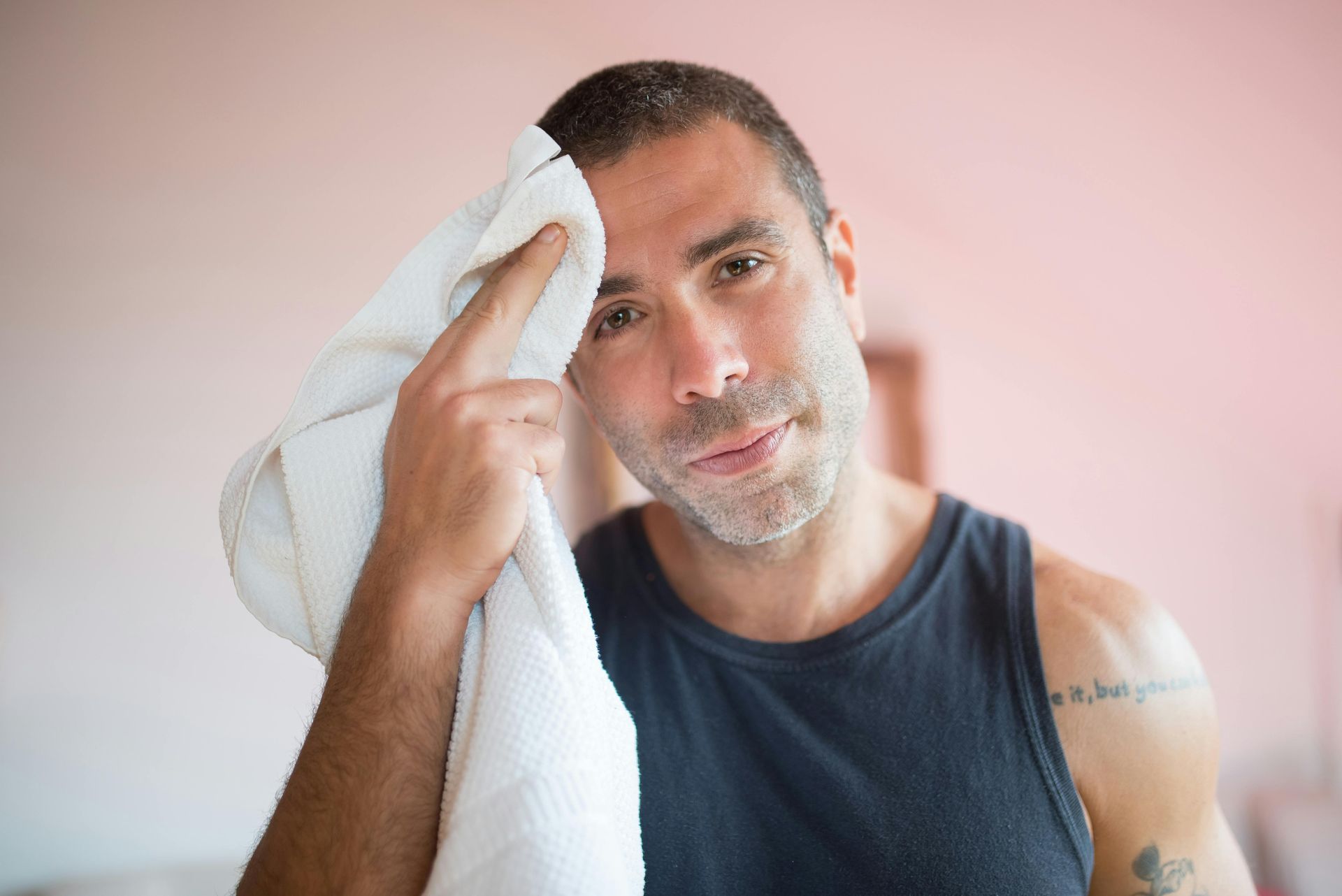Man wiping the sweat off his face after exercise