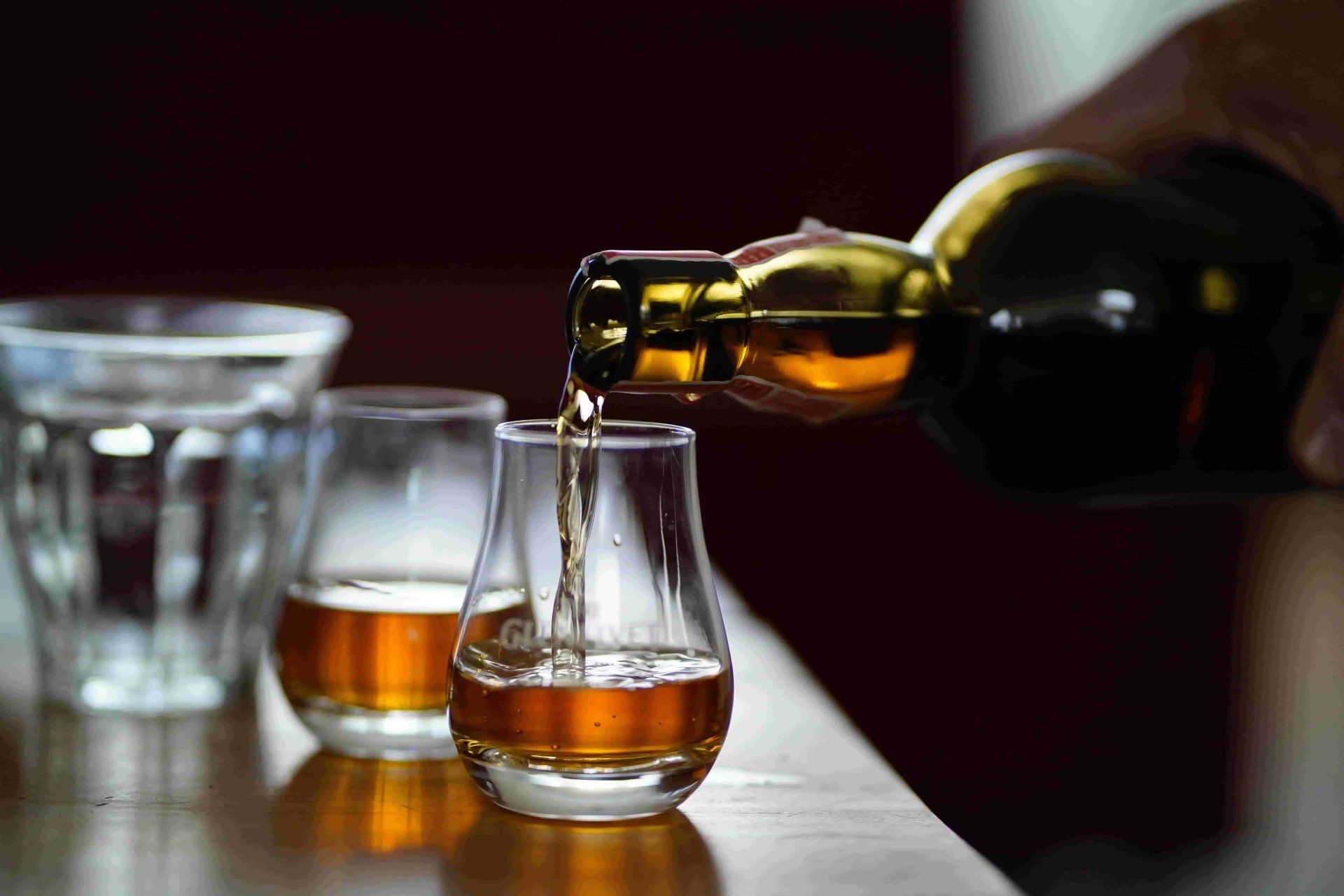 Whisky poured in to glasses in Loch Fyne pub.
