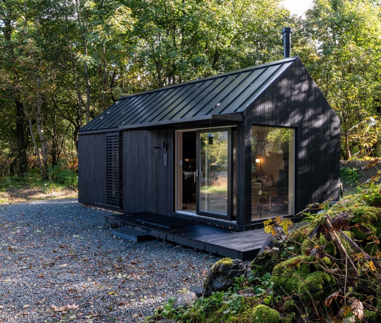 Exterior of a black luxury self catered cabin in nature.