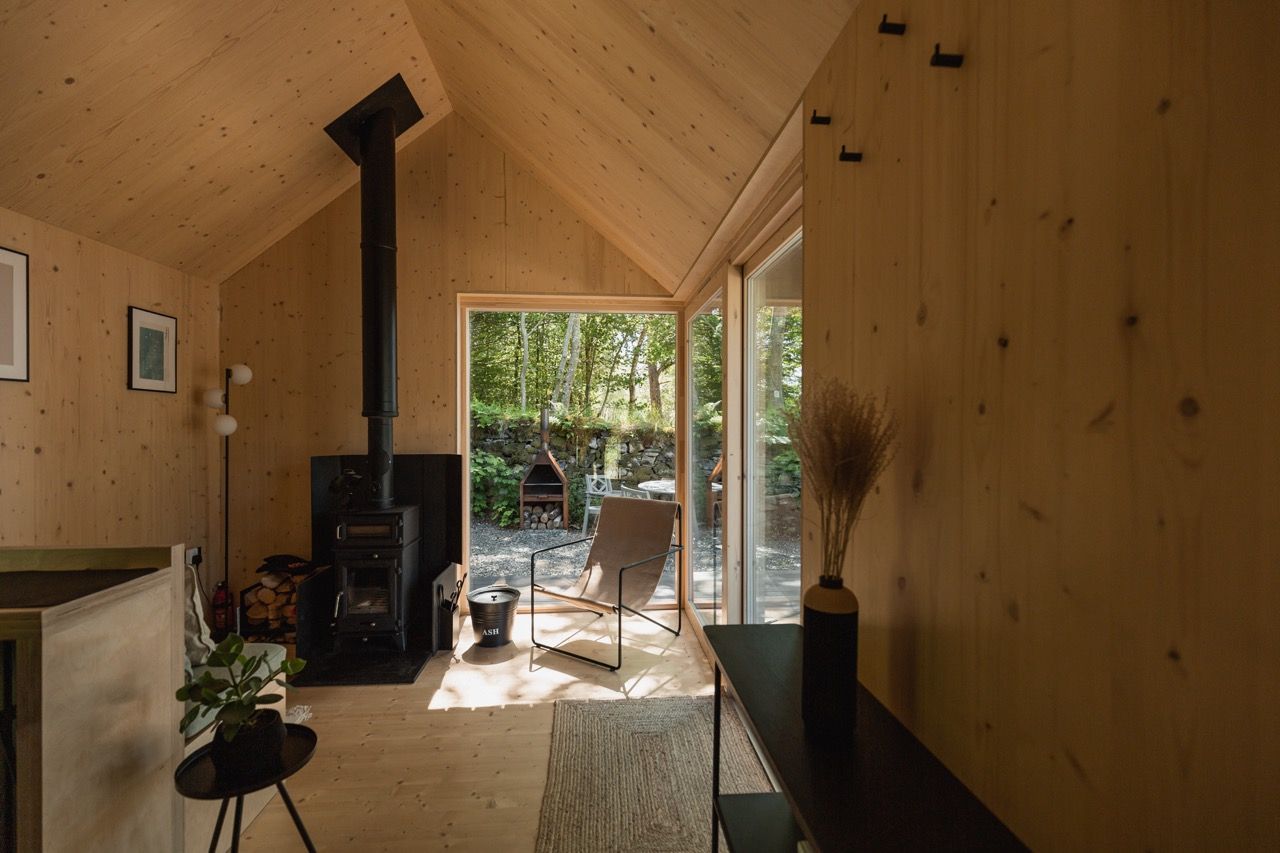 Minimalist cabin interior with natural light and woodland views in Scotland
