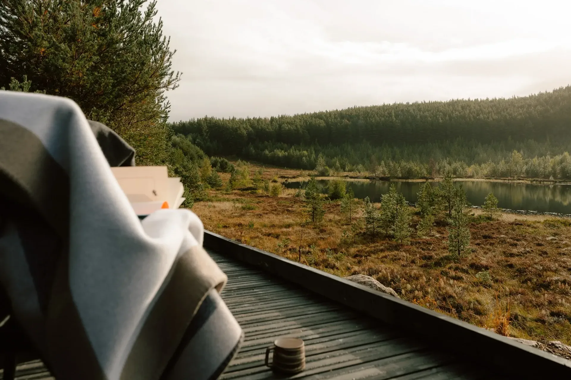Private terrace at Moya Kabn overlooking a secluded Cairngorms lochan and surrounding woodland