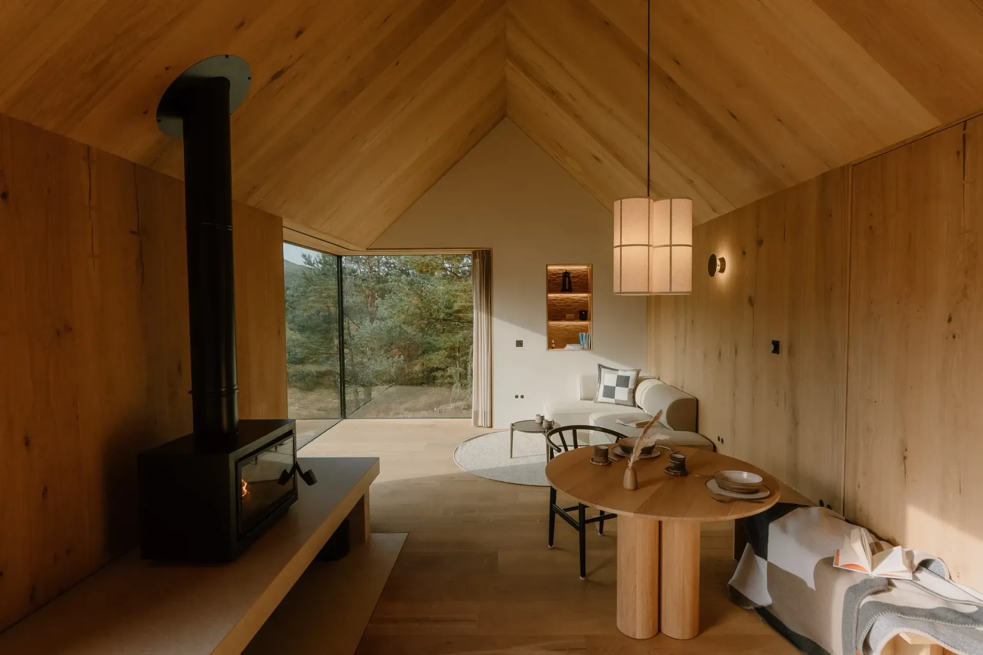 Moya Kabn living room with oak interiors, wood-burning stove and Cairngorms views