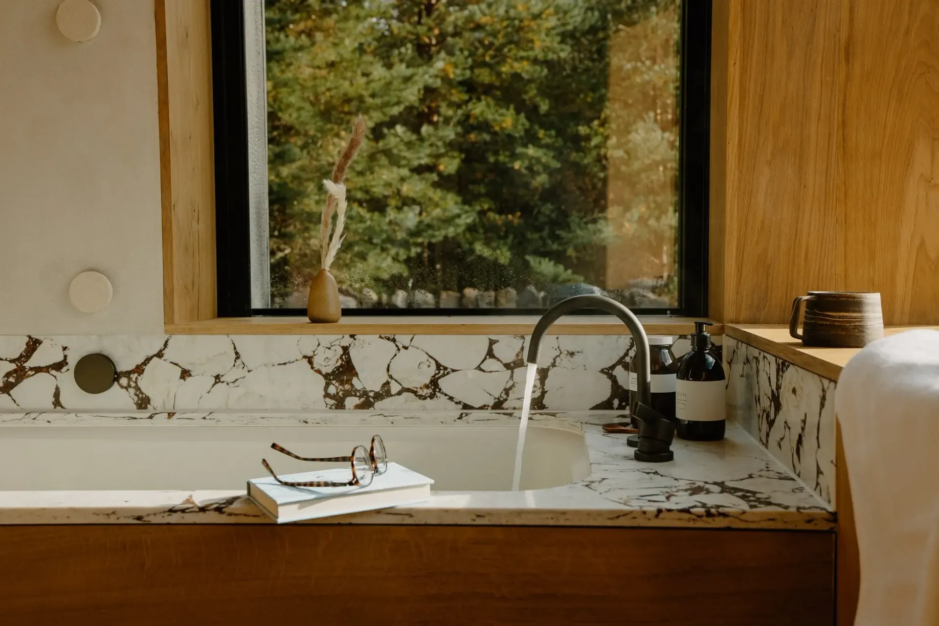 Soaking bath at Moya Kabn with marble surround, oak finishes and Cairngorms woodland views