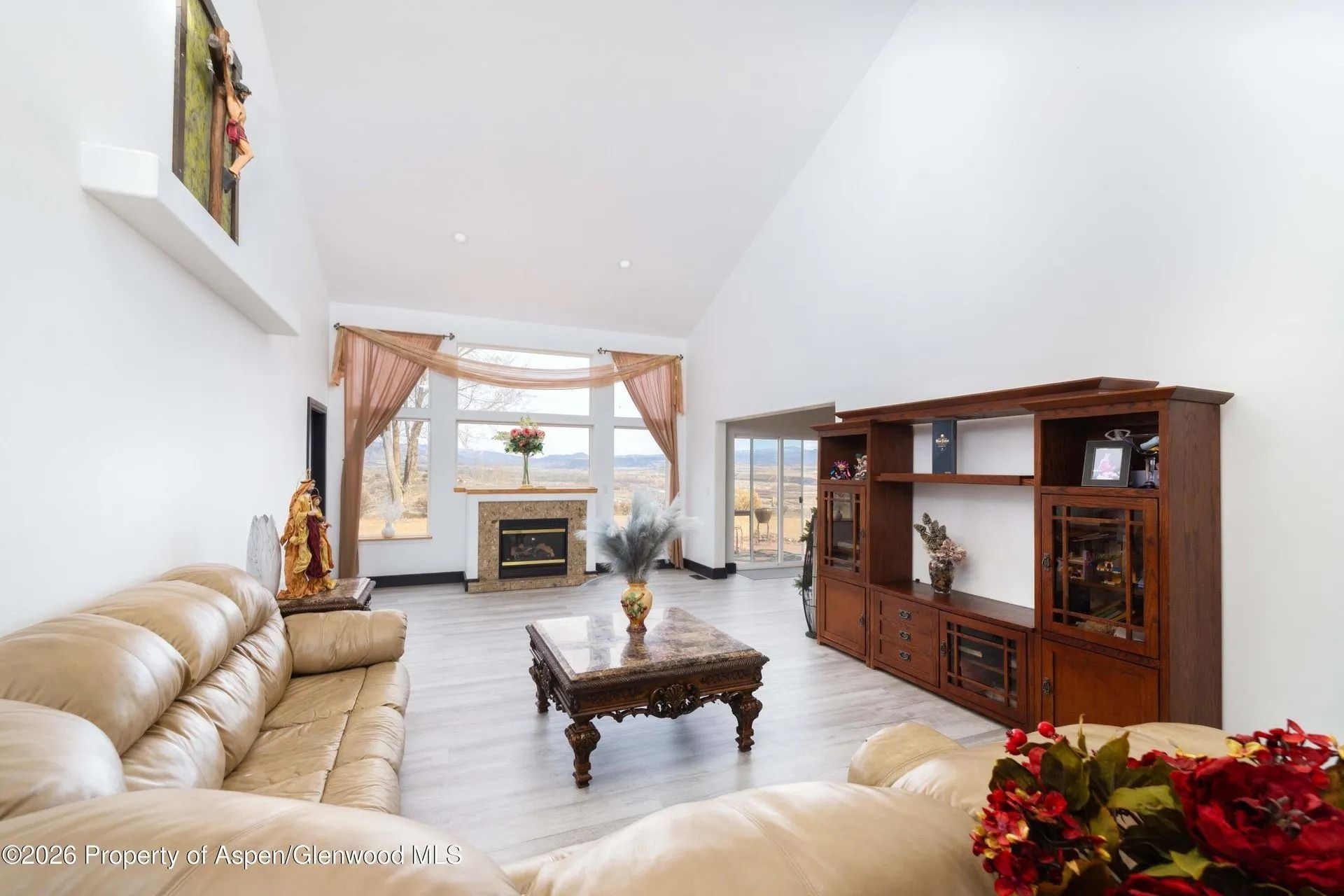 Bright living room with beige sofas, wooden coffee table, and large window overlooking water.