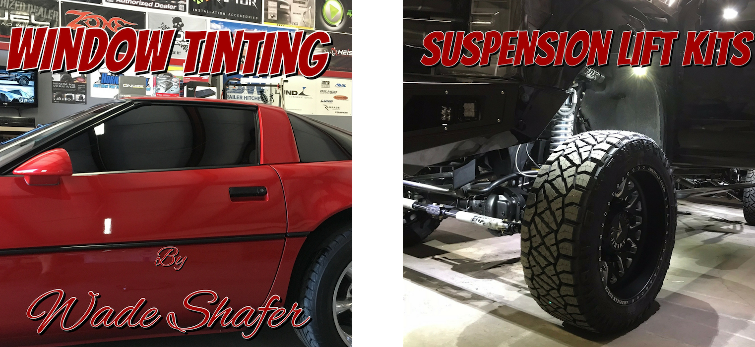 Red sports car with window tinting and a lifted black off-road truck in a garage display