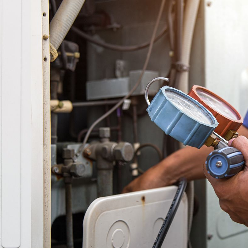 African-American technician working on an AC Unit.
