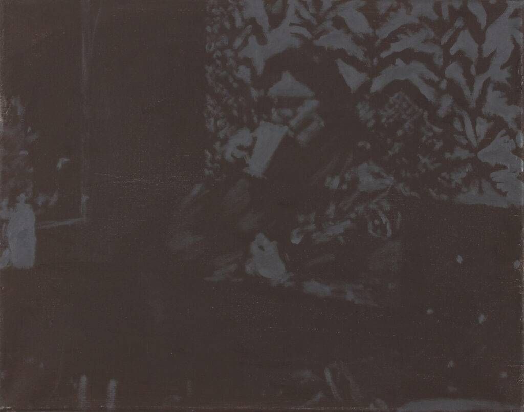 A black and white photo of a person sitting under a tree.