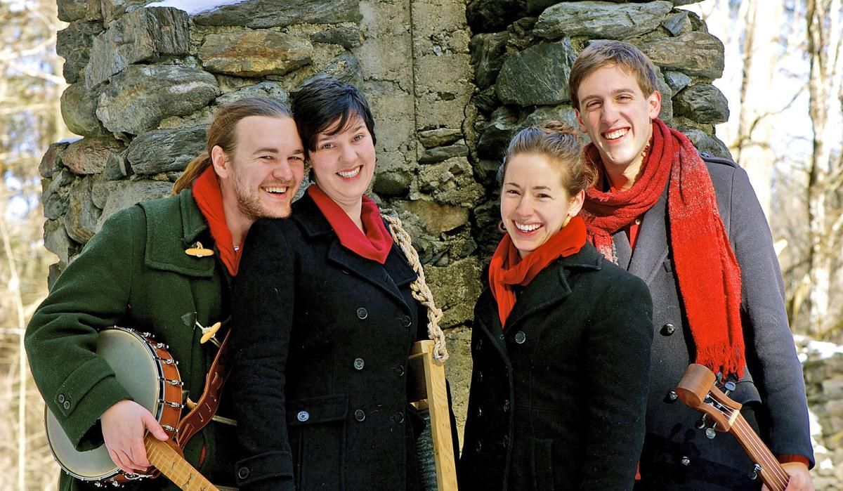 A group of people standing next to each other in front of a stone wall.