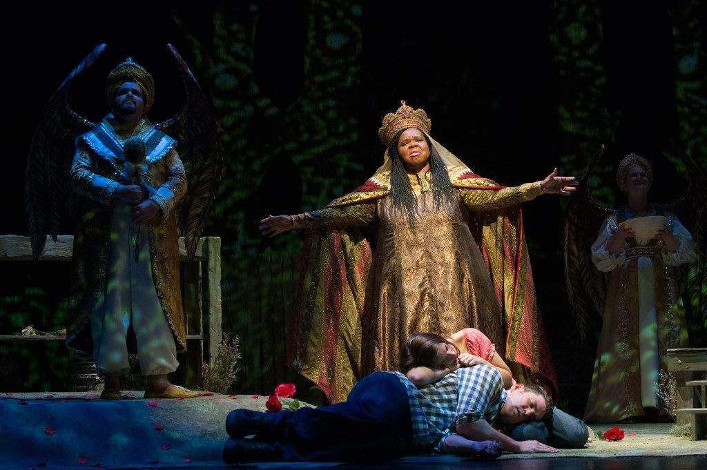A man is laying on the floor in front of a woman on a stage.  Opera