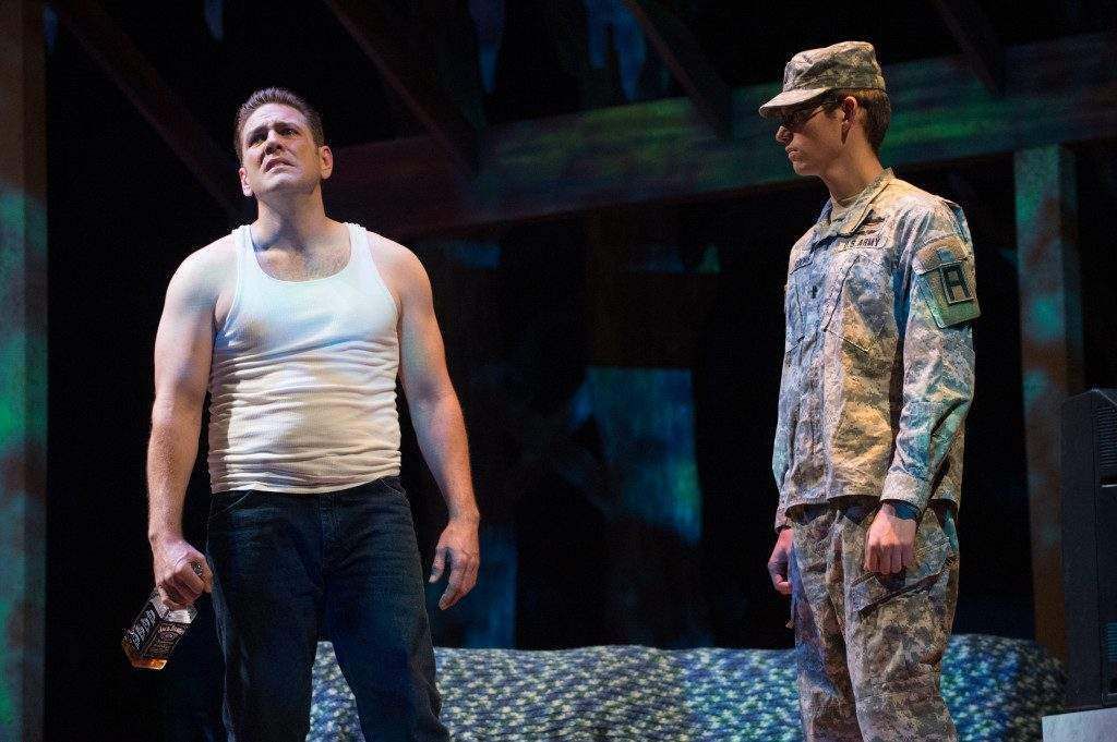 Two men in military uniforms are standing next to each other on a stage.