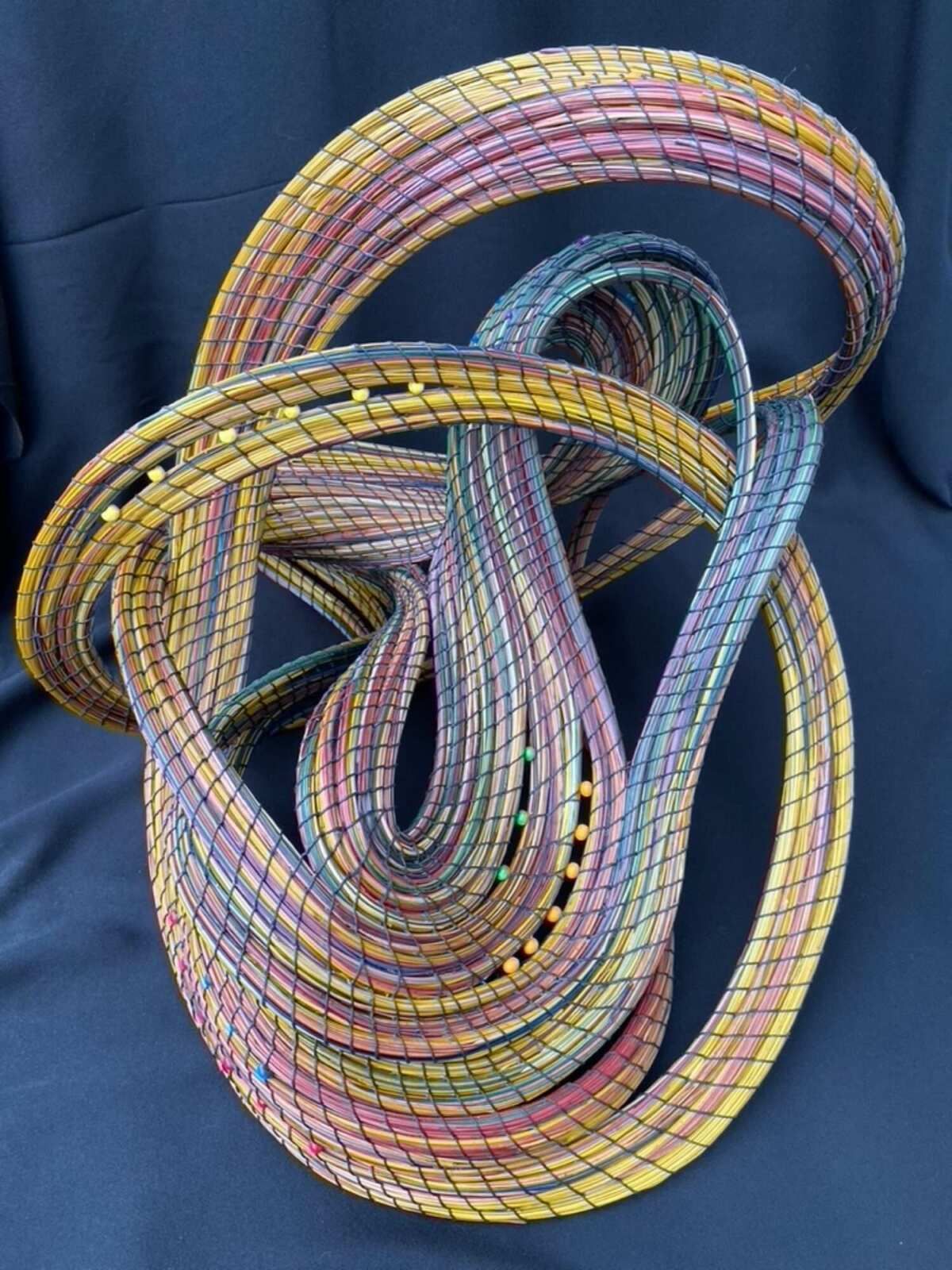 A colorful sculpture is sitting on a black cloth