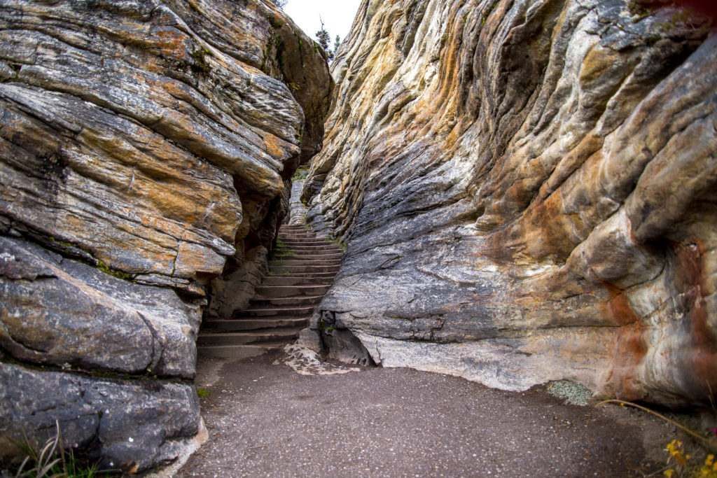 There are stairs leading up to a cave in the rocks.