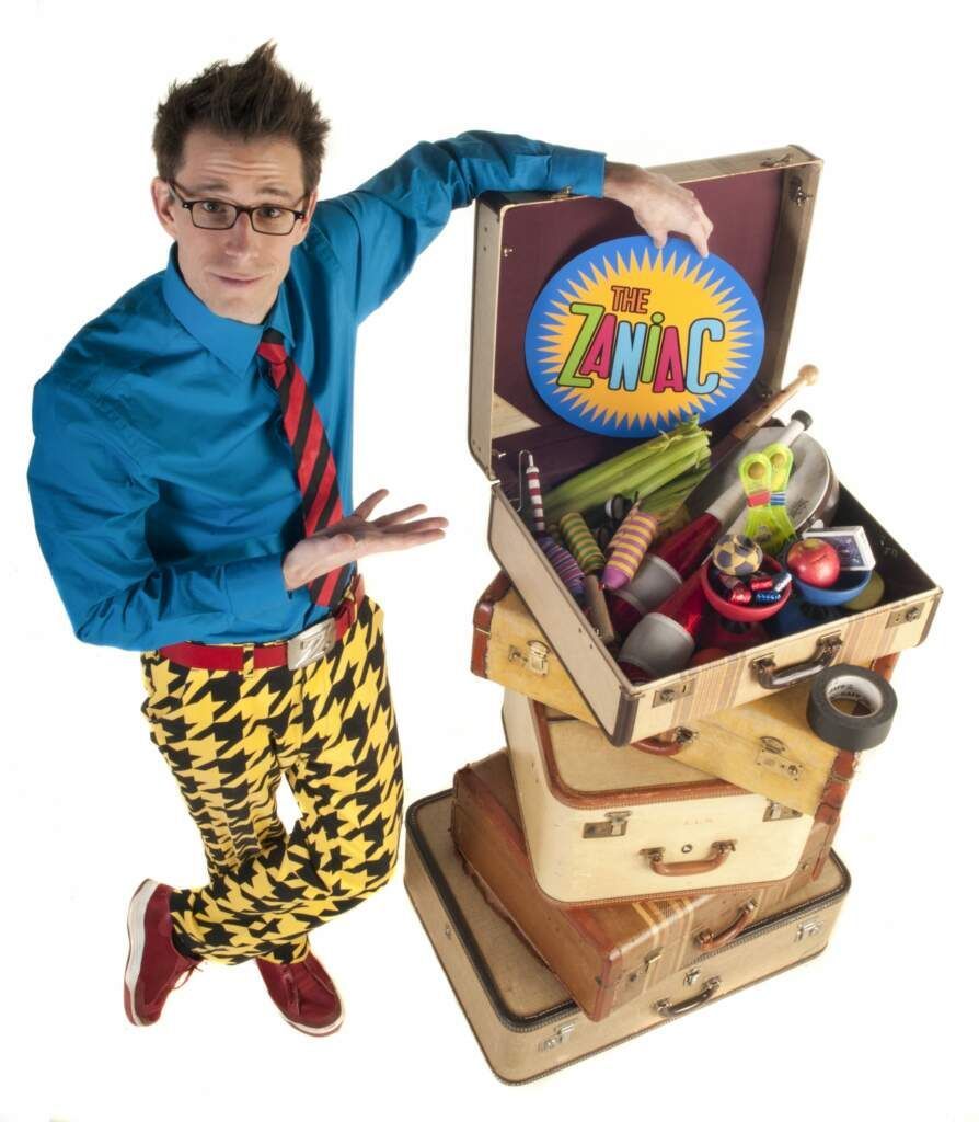 A man is standing next to a stack of suitcases and a suitcase that says the twac