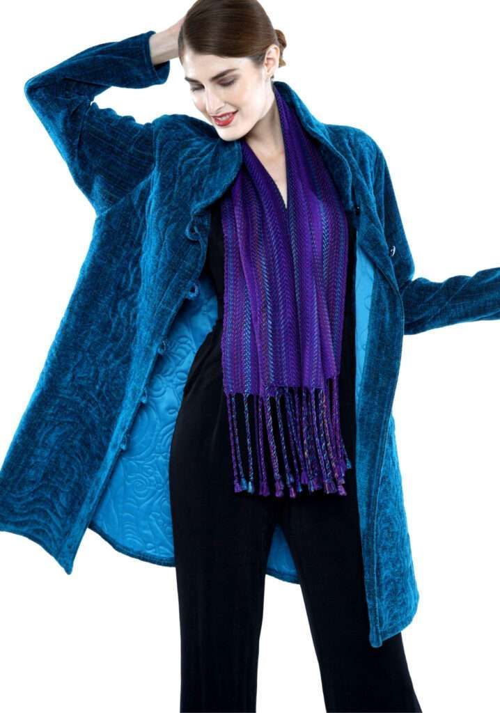 A woman wearing a blue coat and a purple scarf