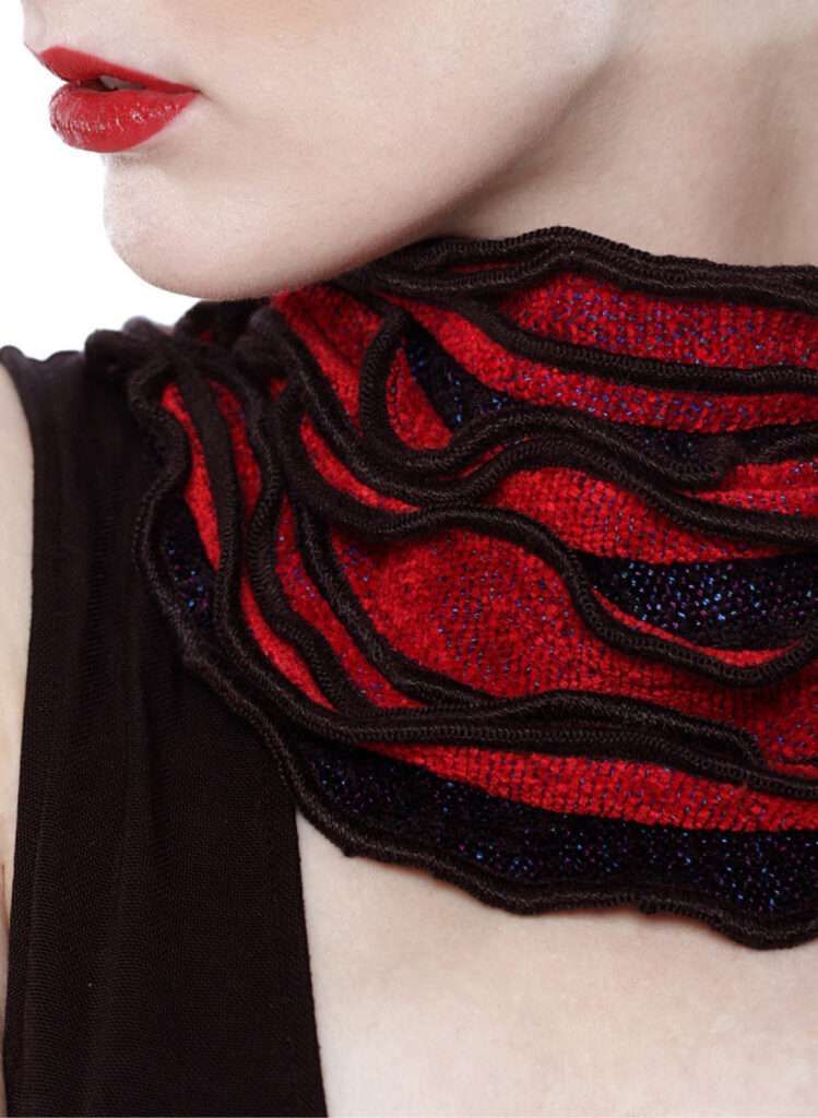 A woman wearing a red and black scarf around her neck