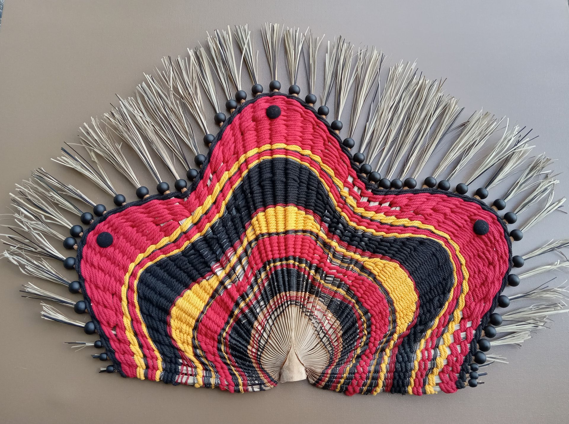 A fan with a red yellow and black design on it