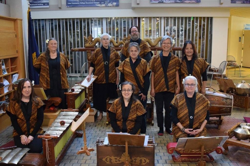 A group of people are posing for a picture in front of musical instruments.