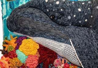 A whale is laying on top of a coral reef in a painting.