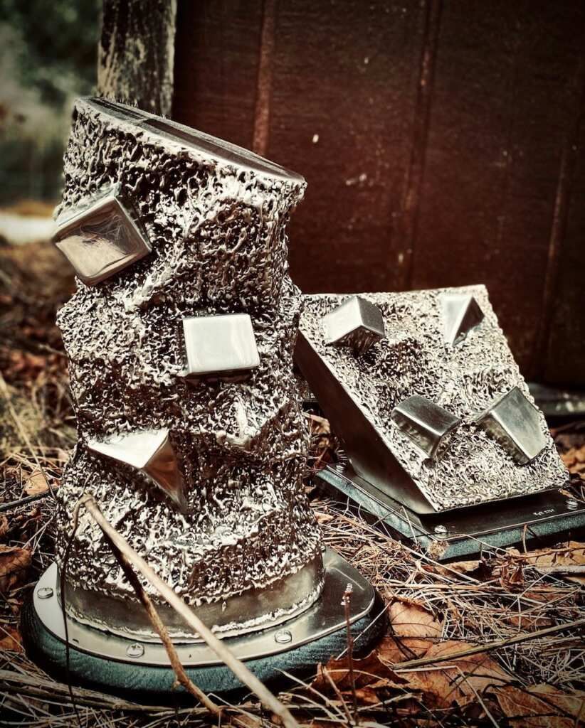 A sculpture made of aluminum foil is sitting on the ground
