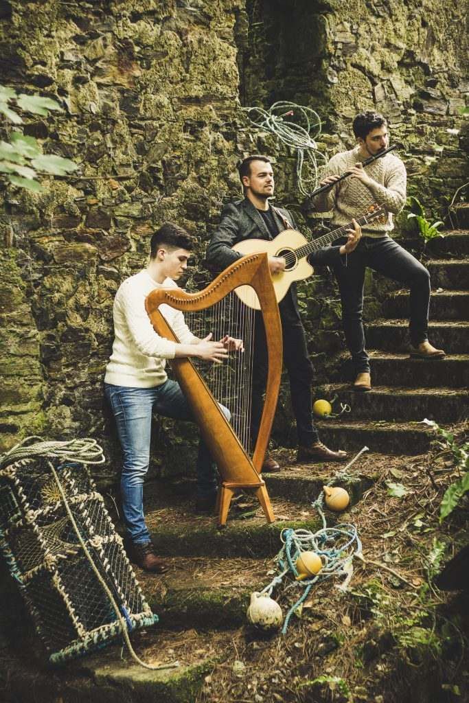 A group of men are playing instruments in front of a brick wall.