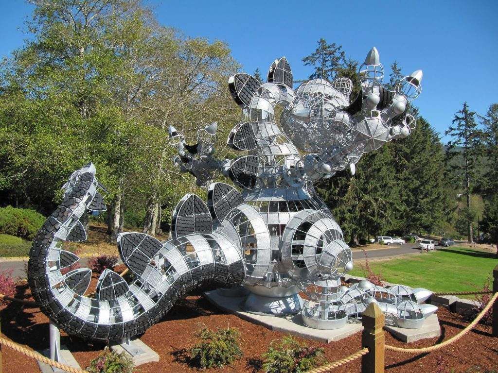A large sculpture of a dragon is surrounded by trees
