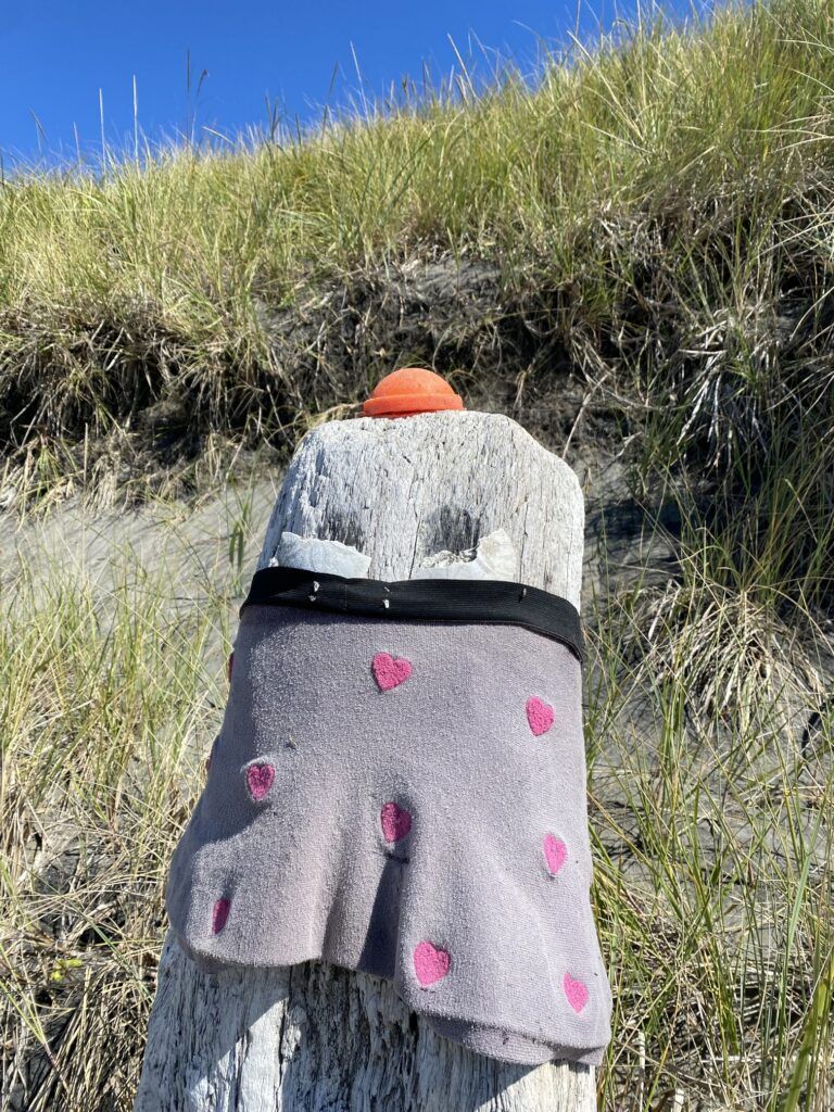 A stuffed animal is sitting on top of a wooden post.