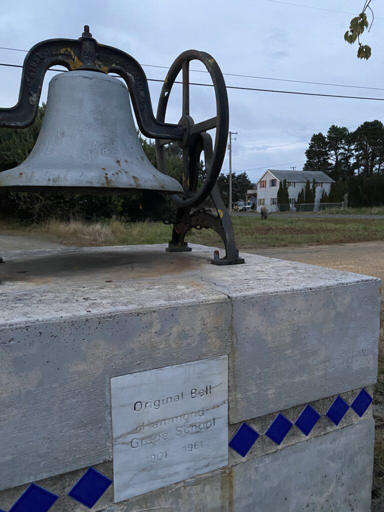A large bell is sitting on top of a concrete block