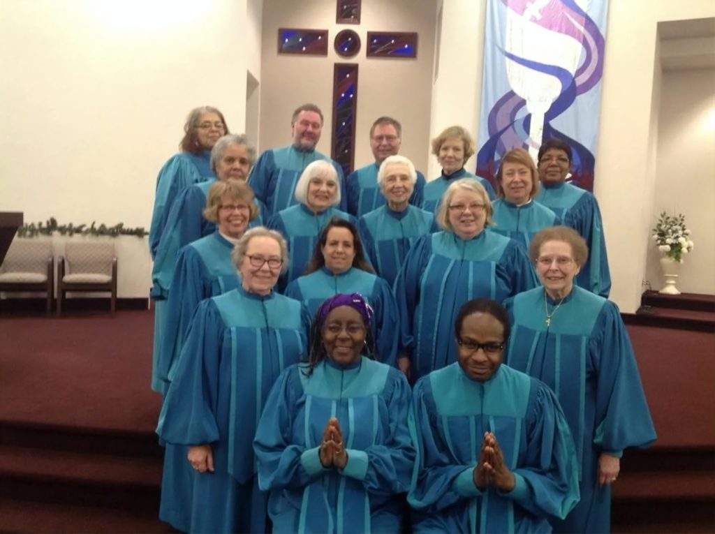 A group of people in blue robes are posing for a picture