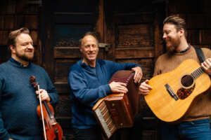 A group of men are standing next to each other playing musical instruments.