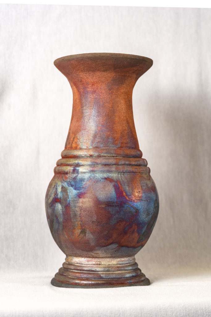 A brown vase is sitting on a white table.